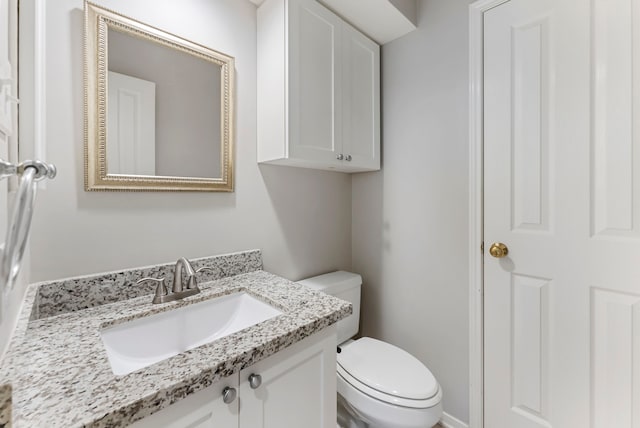 half bathroom with vanity and toilet