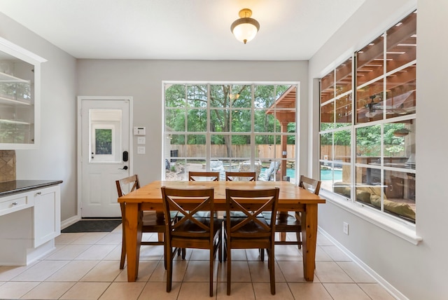 dining area featuring light tile patterned floors, baseboards, and plenty of natural light