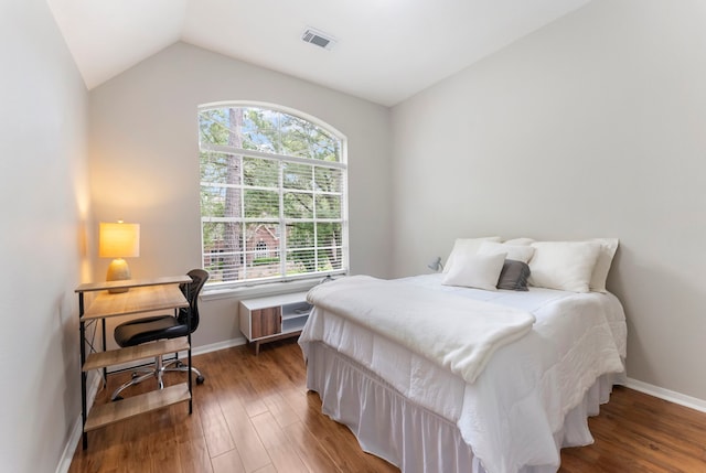 bedroom with baseboards, visible vents, multiple windows, and wood finished floors