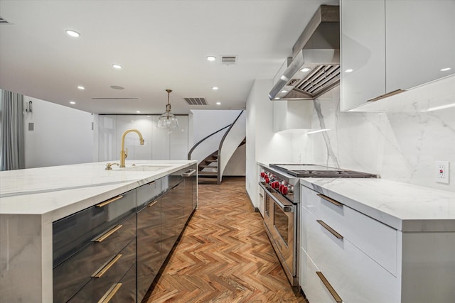5756 Indian Cir, Houston, TX 77057 - kitchen featuring high end stove, modern cabinets, a sink, and wall chimney range hood