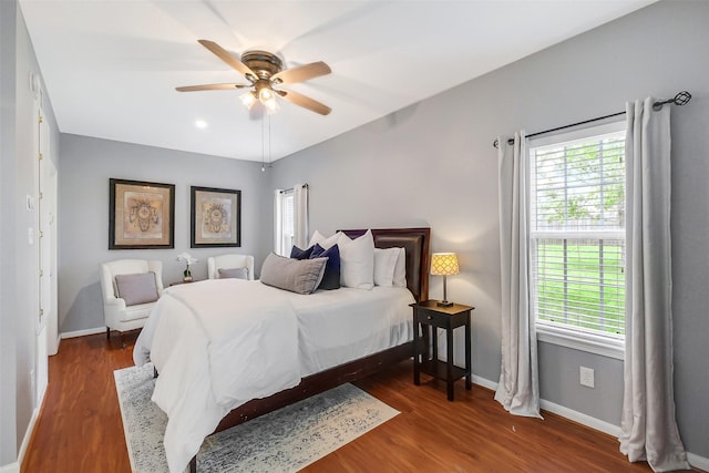 bedroom featuring baseboards, wood finished floors, and ceiling fan