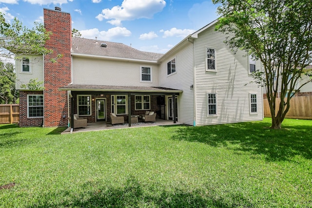 back of house with fence, a patio area, a yard, and an outdoor living space