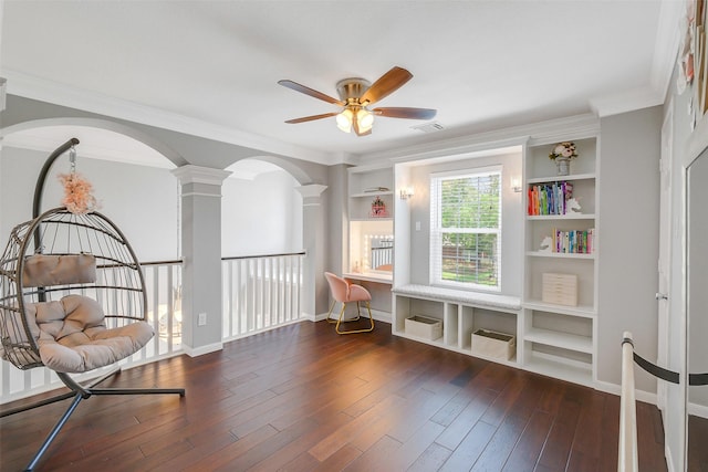 living area featuring wood finished floors, arched walkways, decorative columns, ornamental molding, and ceiling fan
