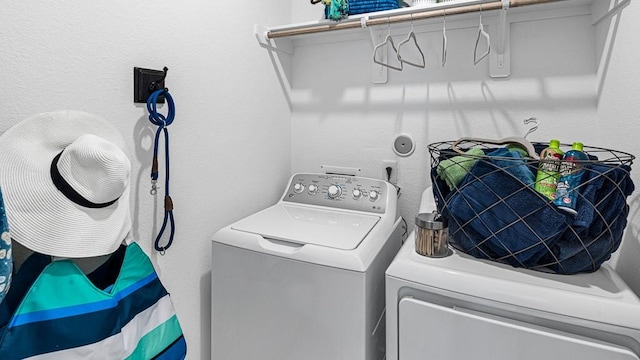 7703 Basil Ridge Dr, Cypress, TX 77433 - clothes washing area with a textured wall, laundry area, and washer and dryer