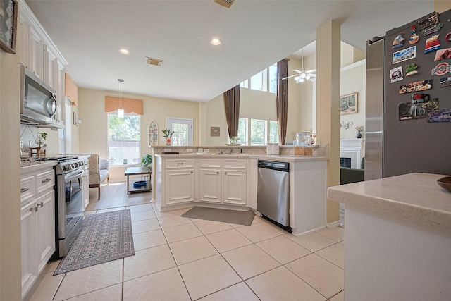 kitchen featuring recessed lighting, stainless steel appliances, light tile patterned floors, light countertops, and white cabinetry