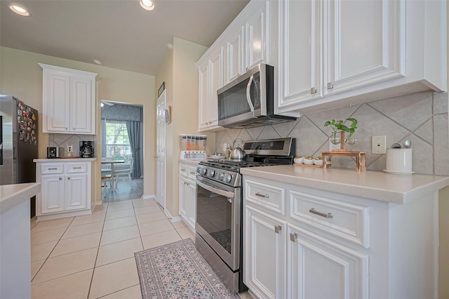 kitchen featuring light tile patterned floors, appliances with stainless steel finishes, light countertops, backsplash, and white cabinetry