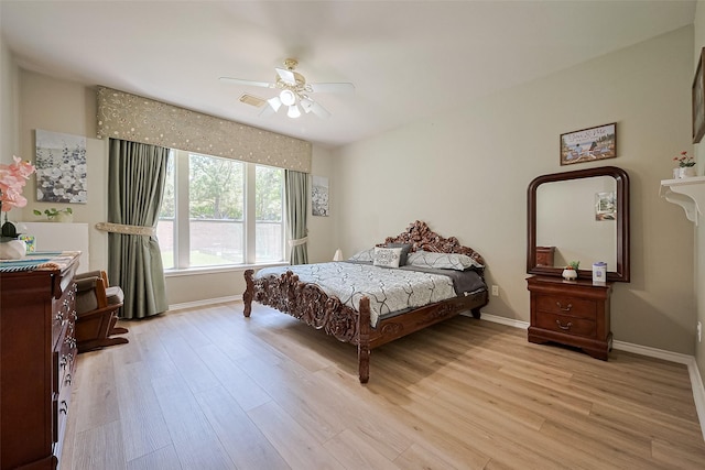 bedroom featuring a ceiling fan, light wood-style flooring, and baseboards
