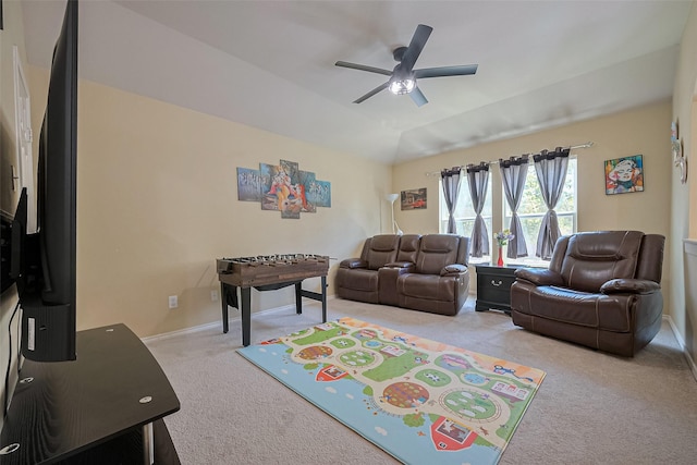 living area with a ceiling fan, baseboards, and light carpet