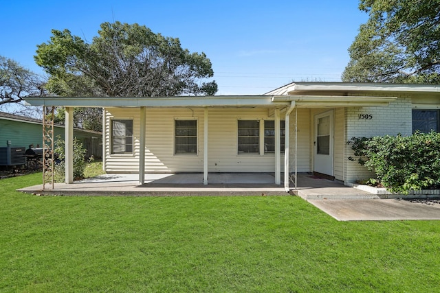 rear view of house with a lawn, covered porch, and central AC