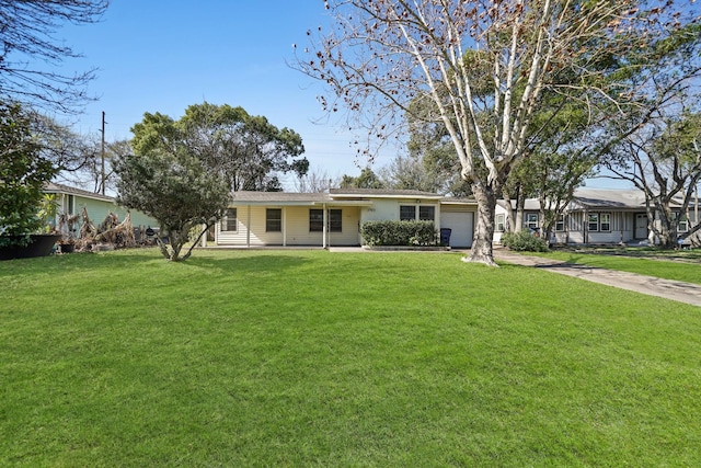 ranch-style home with an attached garage, a front lawn, and driveway