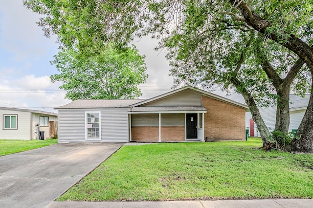 ranch-style home featuring a shingled roof, brick siding, a front lawn, and driveway