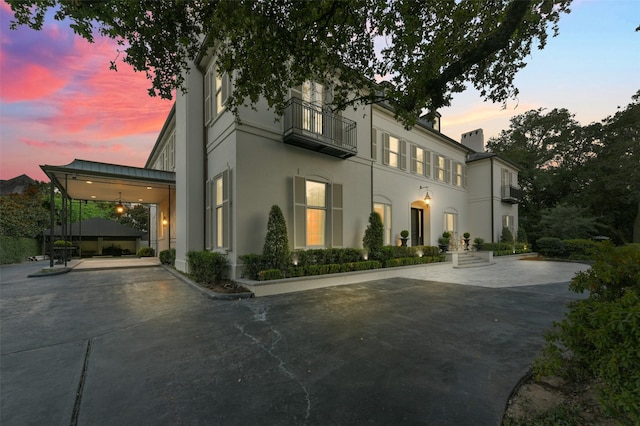 1069 Kirby Dr, Houston, TX 77019 - view of front facade with stucco siding, a chimney, and a balcony
