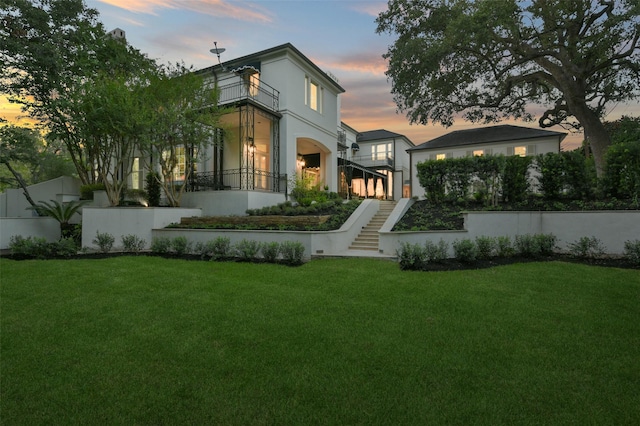 1069 Kirby Dr, Houston, TX 77019 - rear view of house featuring stucco siding, a balcony, a yard, and stairs