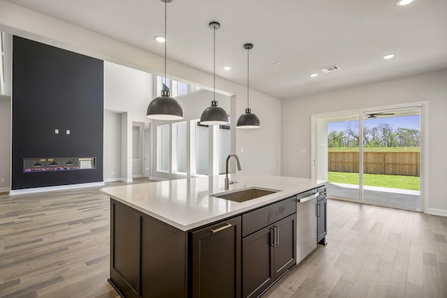 9722 Leafgate Ct, Missouri City, TX 77459 - kitchen with stainless steel dishwasher, a sink, light wood-style flooring, and light countertops
