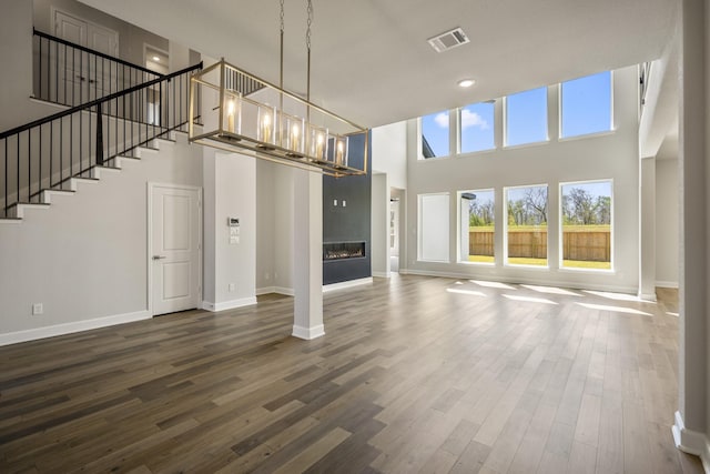 9722 Leafgate Ct, Missouri City, TX 77459 - unfurnished living room with a towering ceiling, wood finished floors, visible vents, and baseboards