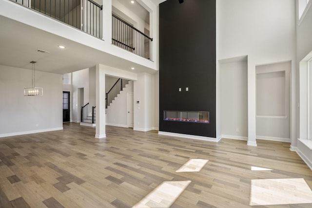 9722 Leafgate Ct, Missouri City, TX 77459 - unfurnished living room with baseboards, light wood-type flooring, and a high ceiling