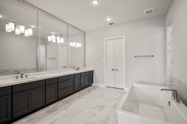 9722 Leafgate Ct, Missouri City, TX 77459 - full bathroom with marble finish floor, a sink, a freestanding tub, and visible vents
