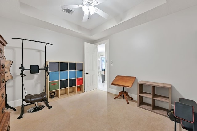 310 Rustic Ln, Friendswood, TX 77546 - exercise room with a tray ceiling, ceiling fan, baseboards, and carpet flooring