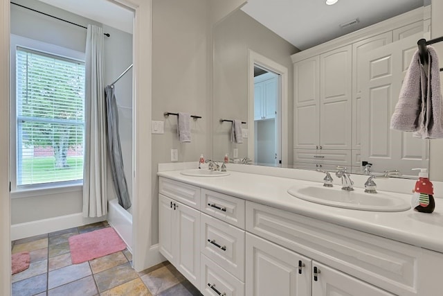 310 Rustic Ln, Friendswood, TX 77546 - bathroom with baseboards, shower / bathtub combination with curtain, double vanity, and stone finish floors