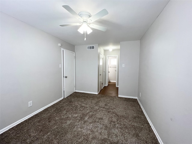 unfurnished bedroom featuring visible vents, dark carpet, ceiling fan, and baseboards