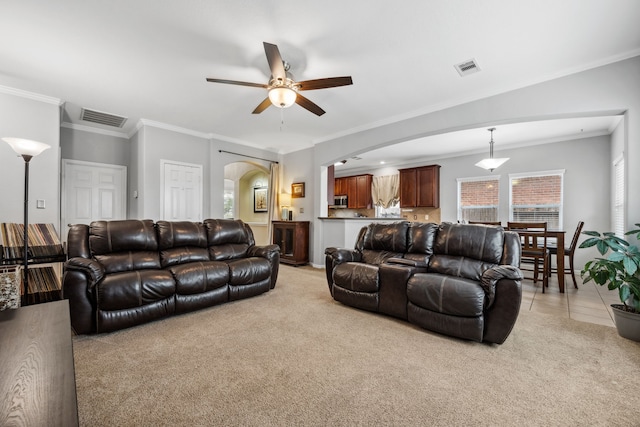 8522 E Highlands Xing, Highlands, TX 77562 - living room featuring arched walkways, light carpet, visible vents, a ceiling fan, and crown molding