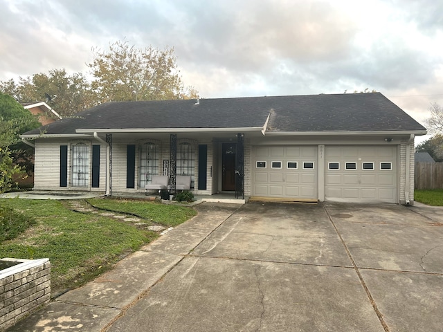 single story home featuring a porch, a garage, roof with shingles, a front yard, and concrete driveway