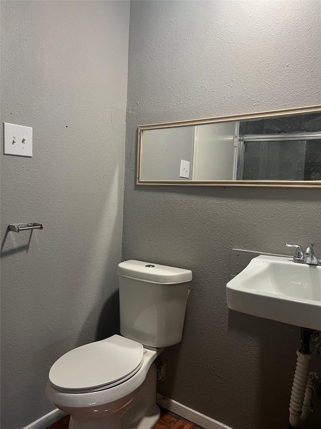 bathroom with toilet and wood finished floors