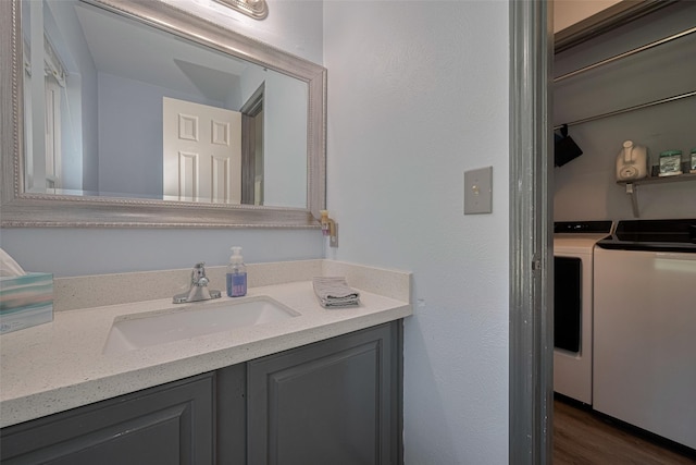 17022 Shadow Valley Dr, Spring, TX 77379 - bathroom with washing machine and clothes dryer, wood finished floors, and vanity