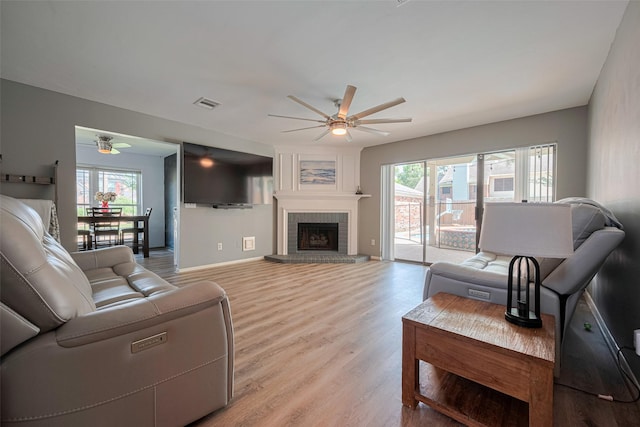17022 Shadow Valley Dr, Spring, TX 77379 - living area featuring ceiling fan, plenty of natural light, light wood finished floors, and a fireplace