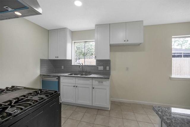 kitchen with a sink, decorative backsplash, black gas range oven, and plenty of natural light