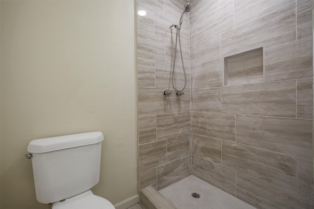 full bathroom featuring a tile shower and toilet