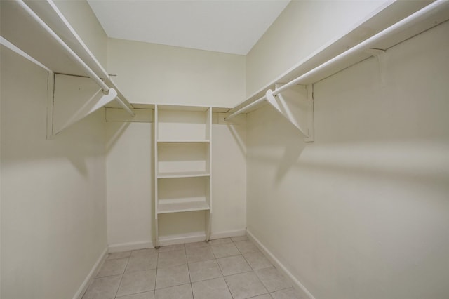 walk in closet with light tile patterned flooring