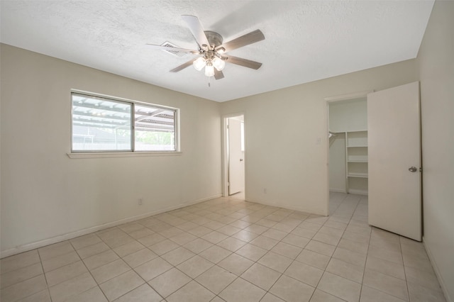 interior space featuring light tile patterned floors, ceiling fan, and a textured ceiling