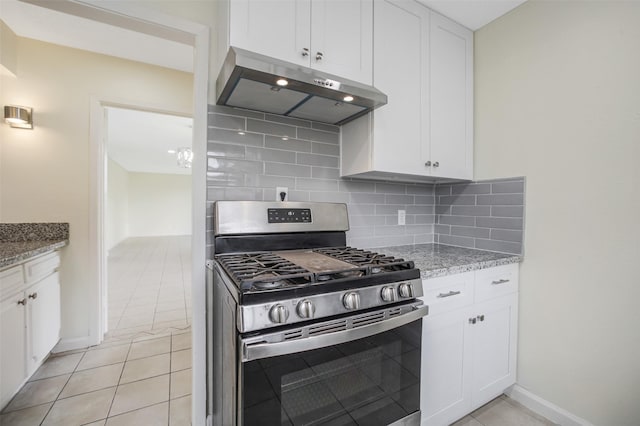 kitchen with stainless steel range with gas stovetop, white cabinetry, light tile patterned floors, backsplash, and under cabinet range hood