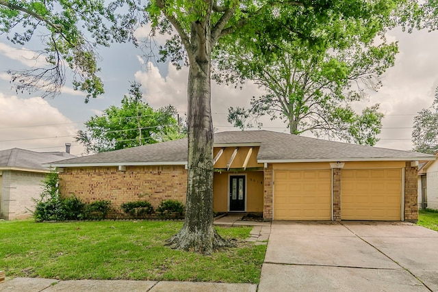 view of front facade featuring brick siding, a garage, roof with shingles, a front yard, and concrete driveway