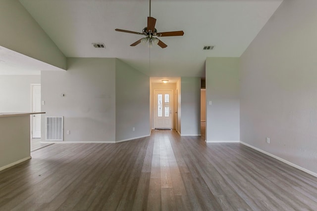 unfurnished living room with visible vents, a ceiling fan, dark wood-style flooring, and vaulted ceiling