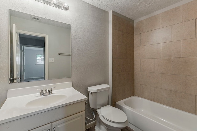 full bathroom with vanity, toilet, visible vents, a textured wall, and a textured ceiling