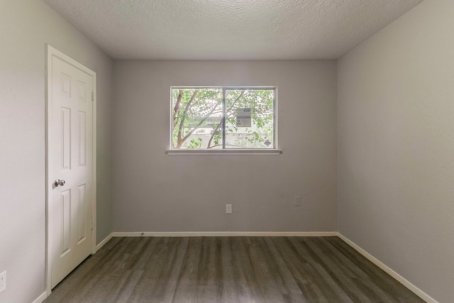 unfurnished bedroom featuring a textured ceiling, wood finished floors, and baseboards