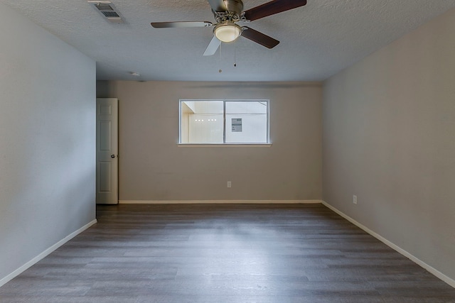 unfurnished room with a textured ceiling, wood finished floors, a ceiling fan, and visible vents