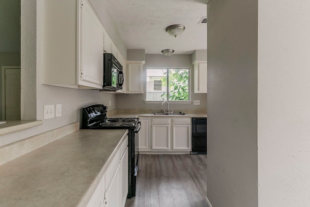 kitchen with light wood-style flooring, light countertops, black appliances, a sink, and white cabinetry