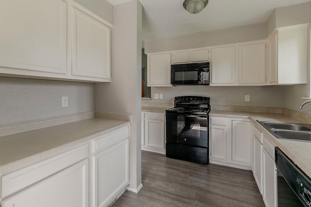 kitchen with black appliances, a sink, dark wood-style flooring, and white cabinetry