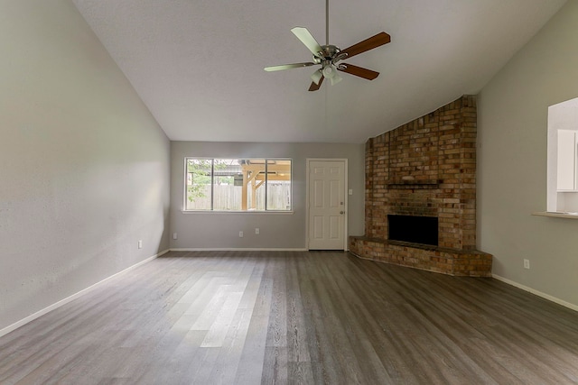unfurnished living room with a ceiling fan, vaulted ceiling, wood finished floors, and a fireplace