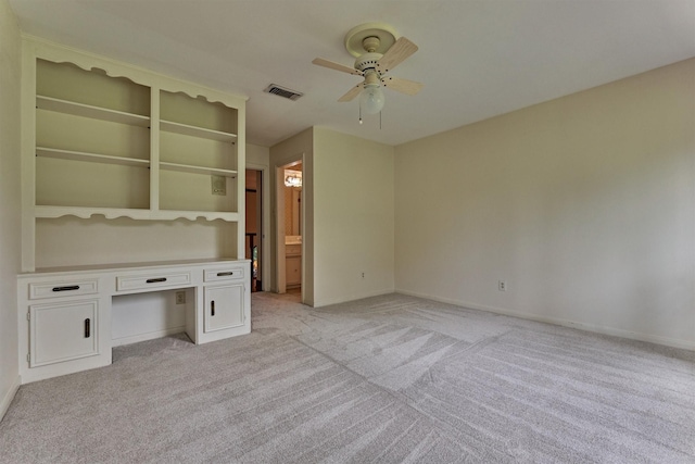 interior space with visible vents, baseboards, ceiling fan, and light colored carpet