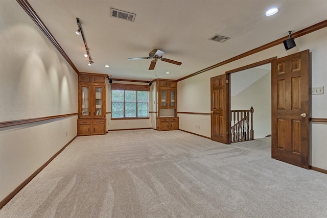 spare room featuring ceiling fan, visible vents, ornamental molding, and light carpet