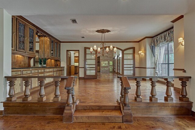 unfurnished dining area featuring visible vents, baseboards, a chandelier, and hardwood / wood-style flooring