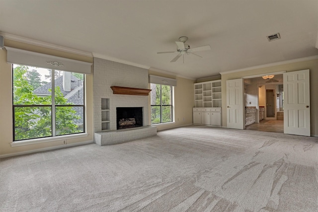unfurnished living room featuring ceiling fan, visible vents, crown molding, a brick fireplace, and carpet floors