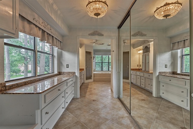 full bathroom with an inviting chandelier, ornamental molding, tile patterned floors, and two vanities