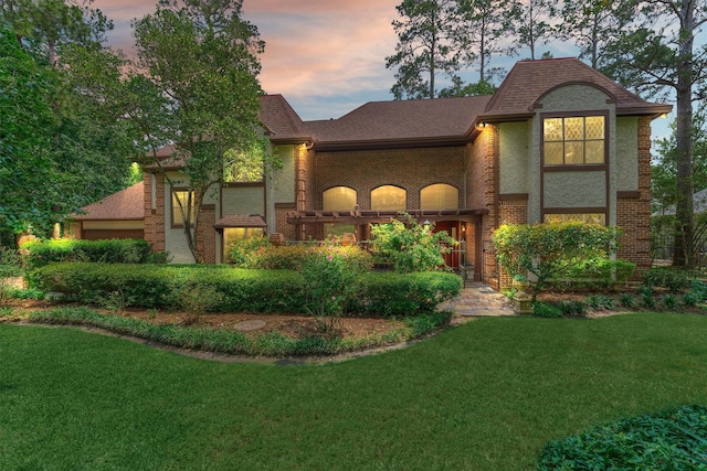 view of front of home with a lawn and brick siding
