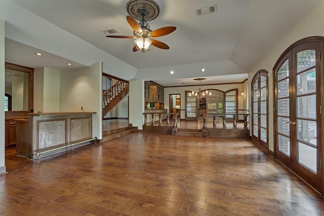 spare room featuring wood-type flooring, stairs, a wealth of natural light, and visible vents