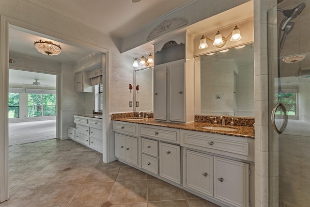 full bath with double vanity, tile patterned floors, ornamental molding, and a sink